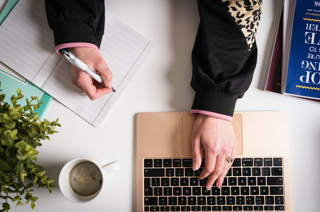 person organizing notes on laptop